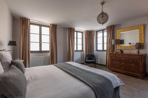 a bedroom with a bed and a dresser and a mirror at LA FERME D'ELISA in Epfig