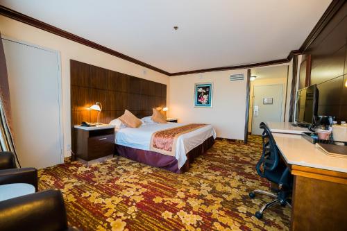 a hotel room with a bed and a desk at LA Crystal Hotel -Los Angeles-Long Beach Area in Carson