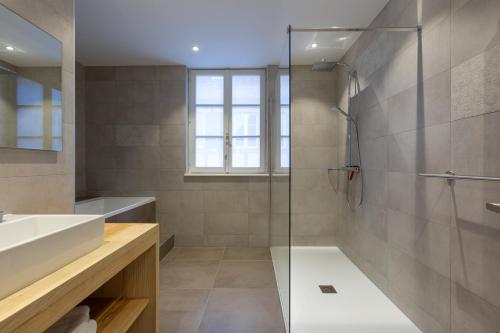 uma casa de banho com uma cabina de duche em vidro e um lavatório. em LA FERME D'ELISA em Epfig