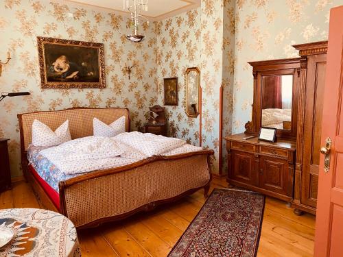 a bedroom with a bed and a dresser in it at Altes Handelshaus Plauen in Plauen