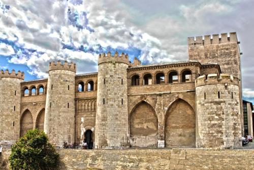 a large castle with towers and a cloudy sky at MODERNO NUEVO Luminoso WI-FI PLAZA DEL PILAR 2 in Zaragoza