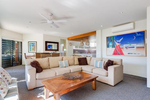a living room with a couch and a table at Nautilus Beachfront Villas & Spa in Coffs Harbour