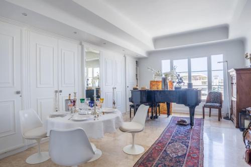 un salon avec une table et un piano dans l'établissement Art Deco Luxury Apartment with Breath Taking View on Cannes Bay by Olidesi, à Cannes