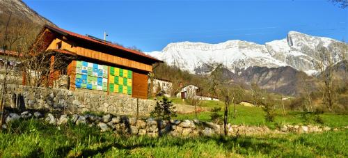 a building with a colorful mural on it in front of mountains at Sleeping with the bees Kozjak in Kobarid