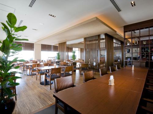 a restaurant with wooden tables and chairs and a cafeteria at Gamagori Onsenkyo Mikawa Bay Hills Hotel in Nishio