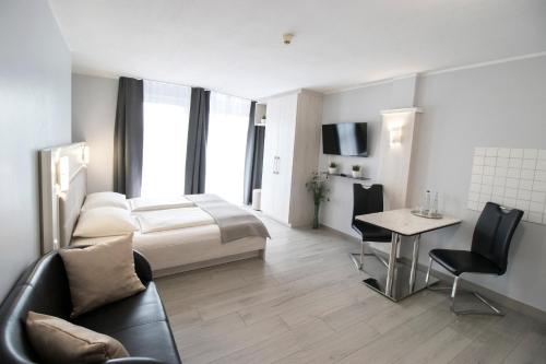 a hotel room with a bed and a table and chairs at ARABEST Aparthotel & Boardinghouse in Munich