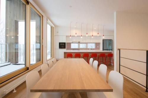a dining room with a wooden table and red chairs at Fuga no Mori by H2 Life Fuga no Mori in Kutchan