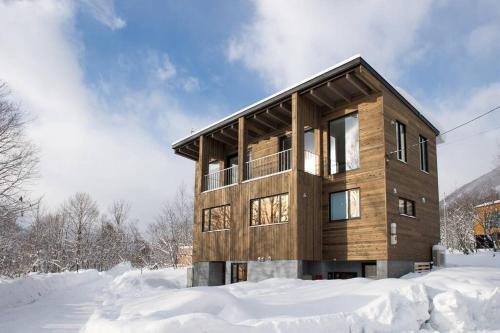 a wooden house in the snow at Fuga no Mori by H2 Life Fuga no Mori in Kutchan
