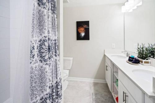 uma casa de banho com uma cortina de chuveiro e um lavatório em Amazing Thematic 2BR with Waterpark em Kissimmee