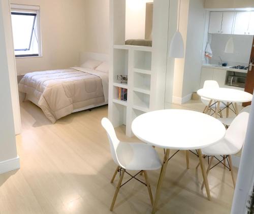 a bedroom with a bed and a table and chairs at Tudo próximo a você in São Paulo