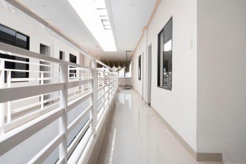 an empty hallway in a building with white walls at RedDoorz Syariah near Stadion Teladan Medan in Medan