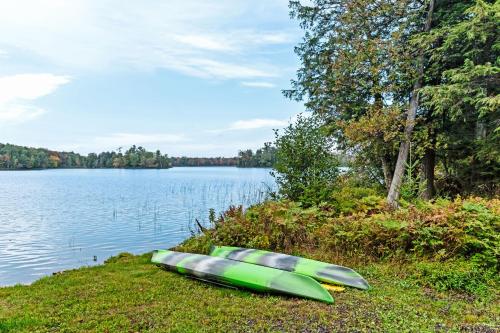 two kayaks sitting on the shore of a lake at Annabelle Log Home in Presque Isle