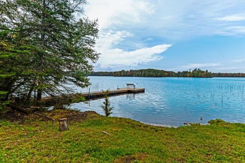 a dock on a lake with a bench on it at Annabelle Log Home in Presque Isle