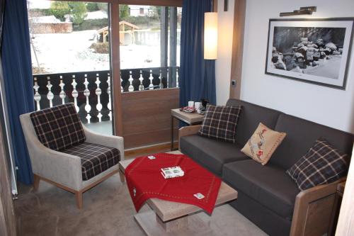 a living room with a couch and a chair at Hotel le Petit Dru in Morzine