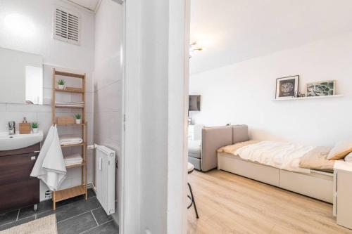 a white bedroom with a bed and a sink at Sauber und modern, Netflix, Wifi, Leipzig Flair, Küche in Leipzig