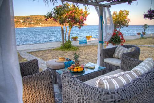 a patio with wicker chairs and a table with fruit at Platys Gialos Hotel Sifnos in Platis Yialos Sifnos