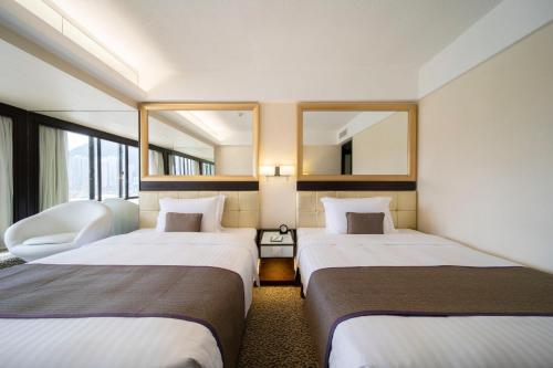 two beds in a hotel room with two mirrors at Regal Oriental Hotel in Hong Kong