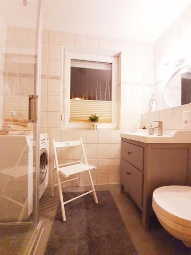 a bathroom with a washing machine and a chair in it at Ferienwohnung Hugo in Zempin
