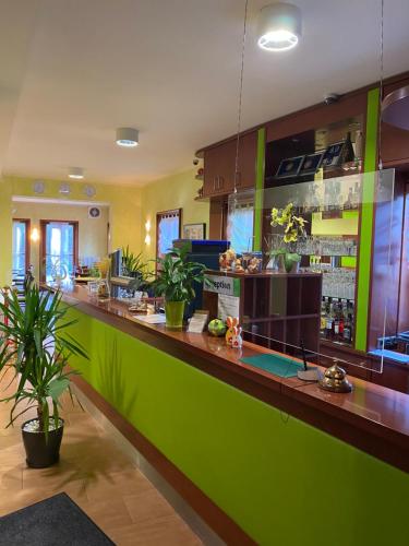 a green bar in a restaurant with plants at Parkhotel Zirndorf in Zirndorf