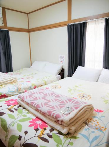 two beds sitting next to each other in a bedroom at 錦の館 NishikiのYakata in Tokyo
