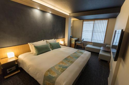 a hotel room with a large bed and a chair at Miru Kyoto Nishiki in Kyoto