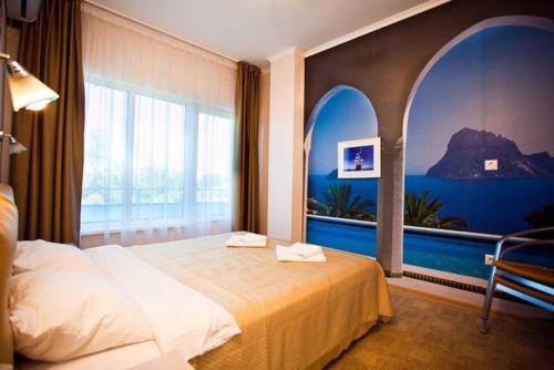 a bedroom with a bed and a large window at Iceberg in Pizunda