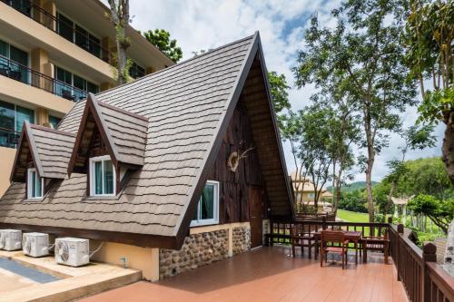 a house with a pitched roof with a patio at Suan Sai Yok Resort in Sai Yok