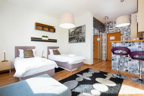 a living room with two beds and a rug at Apartments Warsaw Hoża by Renters in Warsaw