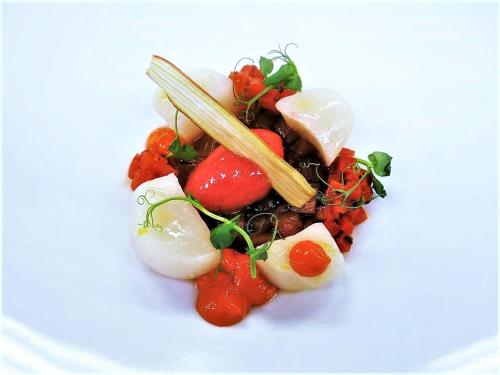 a plate of food with vegetables on a white plate at Parkhotel Flora am Schluchsee in Schluchsee