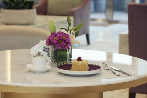 a table with a plate of cake and a cup of coffee at Ayan Furnished Units and Suites in Riyadh