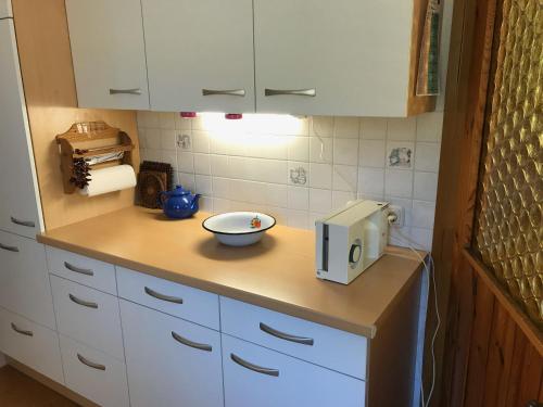 - une cuisine avec des placards blancs et un bol sur un comptoir dans l'établissement Ferienhaus Messern, à Messern