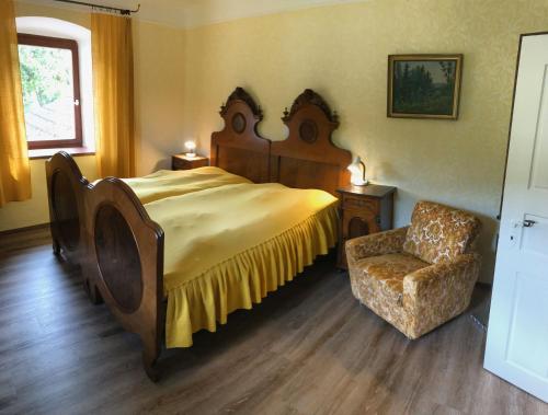 une chambre avec un grand lit et une chaise dans l'établissement Ferienhaus Messern, à Messern