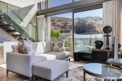 a living room with a couch and a table at Always-Power Luxury De Waterkant Loft Retreat in Cape Town