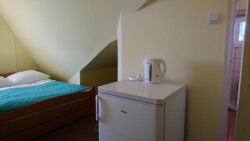 a small room with a small refrigerator and a bed at Zajazd Ustronie in Piaseczno