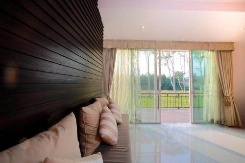 a bedroom with a large bed with a large window at Suan Sai Yok Resort in Sai Yok