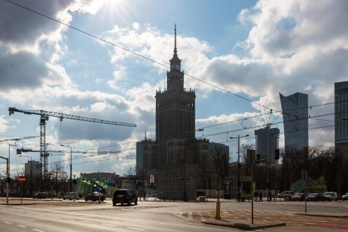 a large building with a tower on a city street at Deluxe Studio Warsaw City Center by Renters in Warsaw