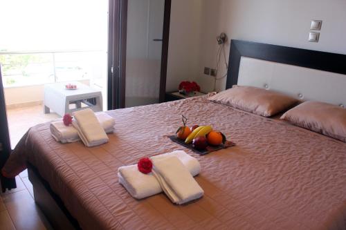 una camera da letto con un letto con asciugamani e frutta di SOPHIAS ad Agios Stefanos