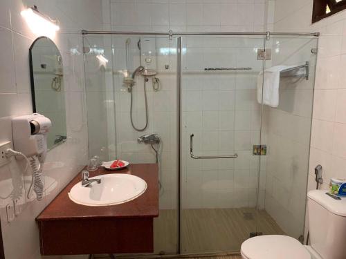 a bathroom with a shower and a sink and a toilet at Hiep Thanh Resort in Phú Quốc