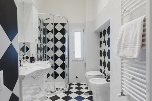 - une salle de bains blanche avec un sol en damier noir et blanc dans l'établissement My Home in San Pietro, à Rome