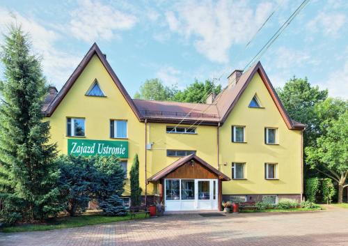 a yellow house with a sign that reads yard furniture at Zajazd Ustronie in Piaseczno