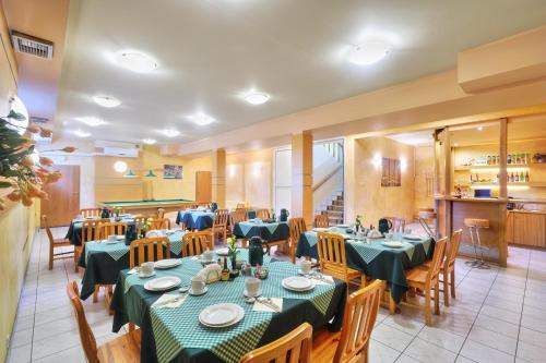 a restaurant with tables and chairs and a kitchen at Zajazd Ustronie in Piaseczno