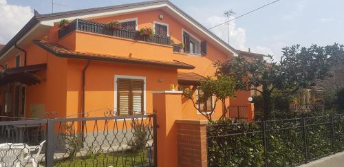 una casa naranja con una valla delante de ella en New Life, en Carrara