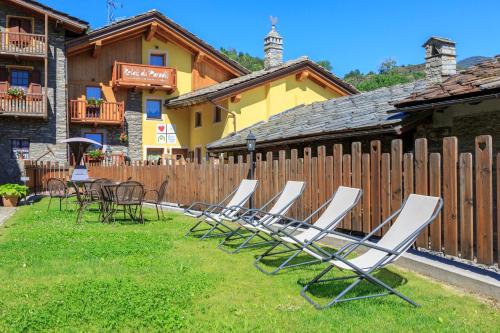 une rangée de chaises longues et de tables dans une cour dans l'établissement Relais du Paradis Chambres d'Hôtes, à Introd