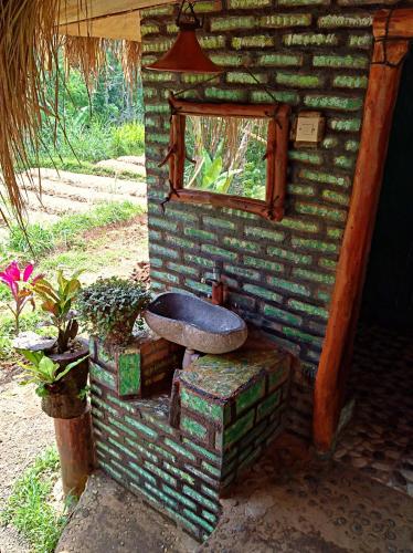 a brick house with a window and a toilet at Satu Lingkung in Tetebatu