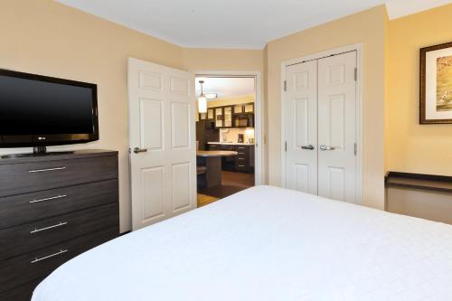 a bedroom with a bed and a flat screen tv at Candlewood Suites Polaris by IHG in Columbus