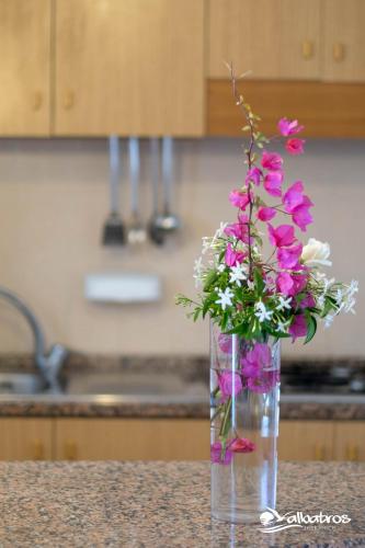 a vase filled with pink flowers sitting on a counter at Residence Albatros in Briatico