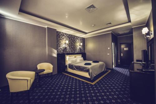 a hotel room with a bed and a table and chairs at Hotel Spa Ice Resort in Timişoara