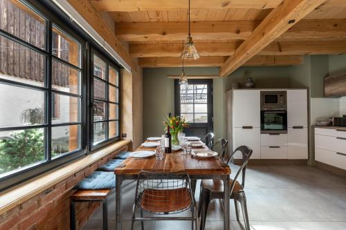 une salle à manger avec une table, des chaises et des fenêtres dans l'établissement LA DEPENDANCE D'ELISA, à Epfig