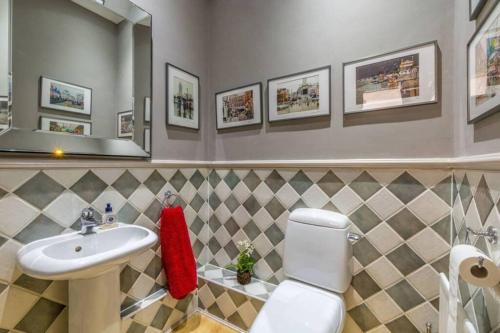 La salle de bains est pourvue d'un lavabo, de toilettes et d'un miroir. dans l'établissement Richmond - 2 Bed court flat with allocated parking, à Richmond