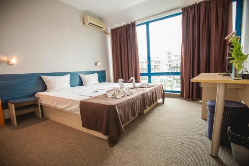 una habitación de hotel con una cama y una ventana grande en Hotel Bohemi, en Sunny Beach